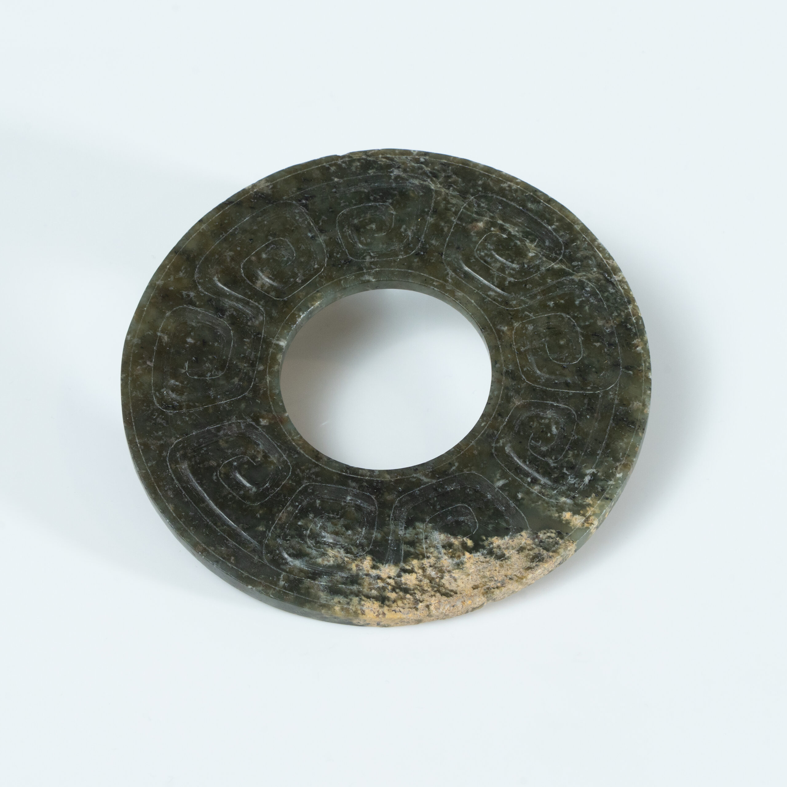 Lot 010 A LARGE ARCHAISTIC CELADON JADE 'CLOUD AND THUNDER' BI-DISC
HAN DYNASTY OR LATER