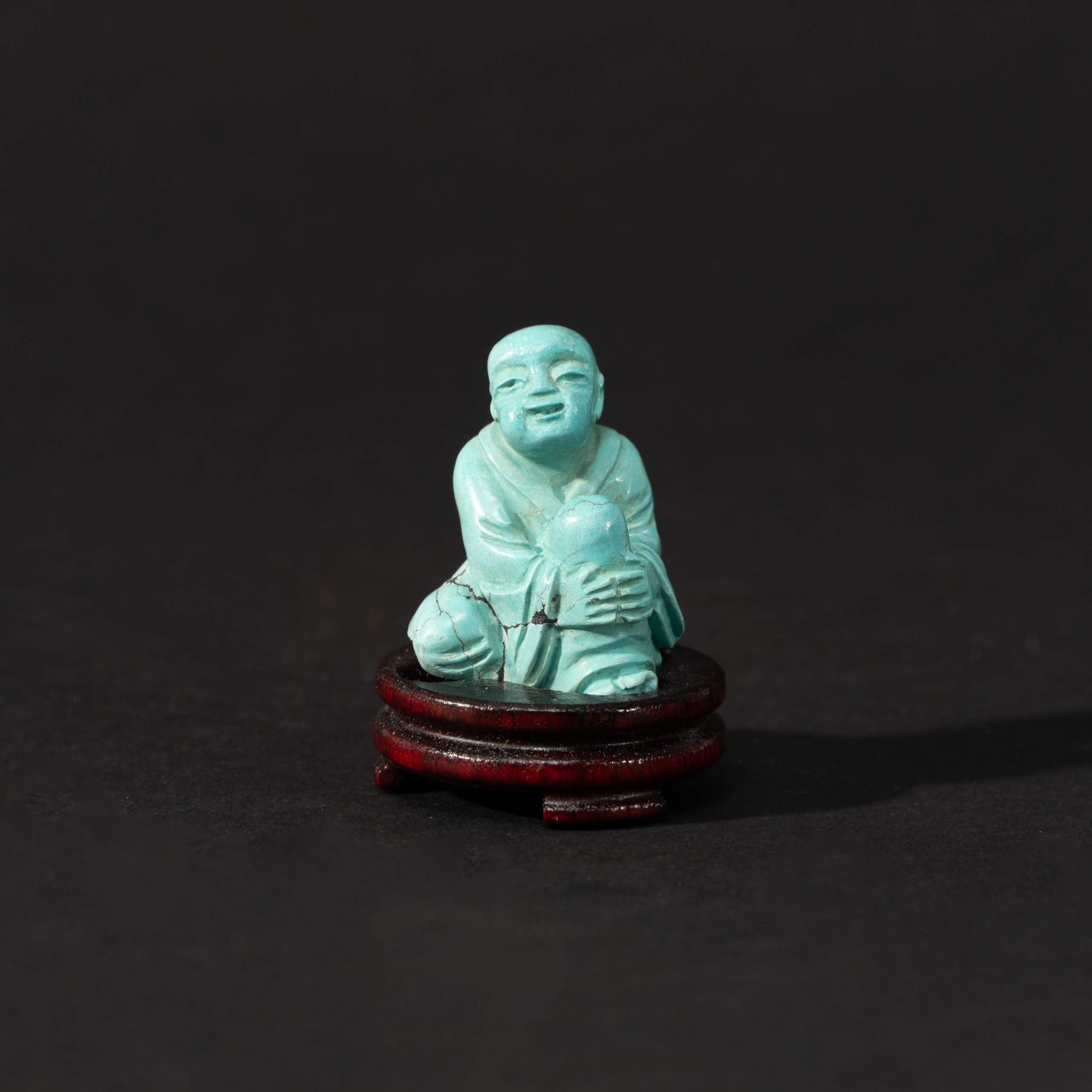 Lot 087 A RARE MINIATURE CARVED TURQUOISE FIGURE OF A SEATED ARHATQING DYNASTY