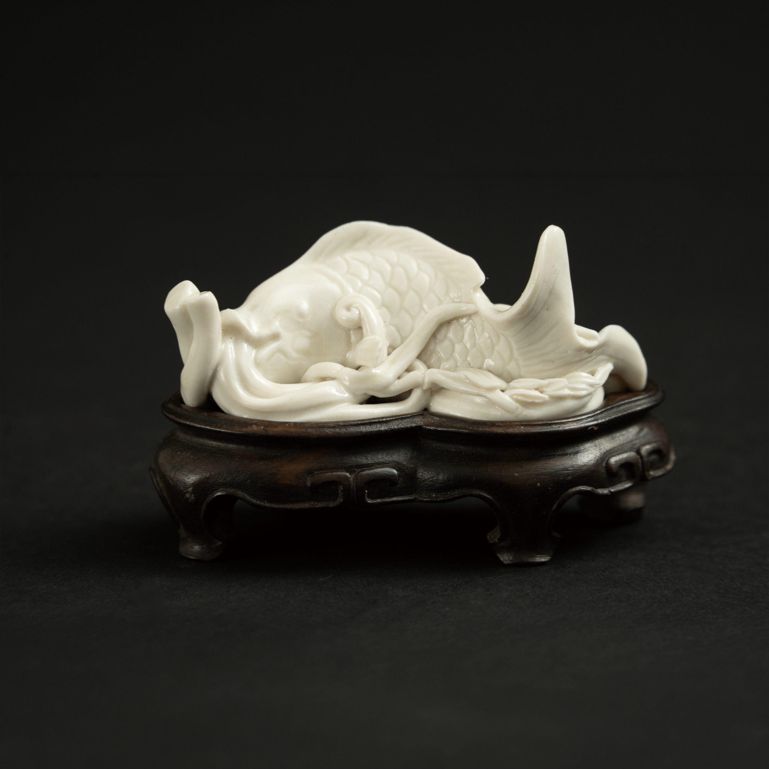 Lot 071 A DEHUA WHITE-GLAZED 'CARP' PAPERWEIGHT
MING DYNASTY
明 德化窑白釉鱼形文镇