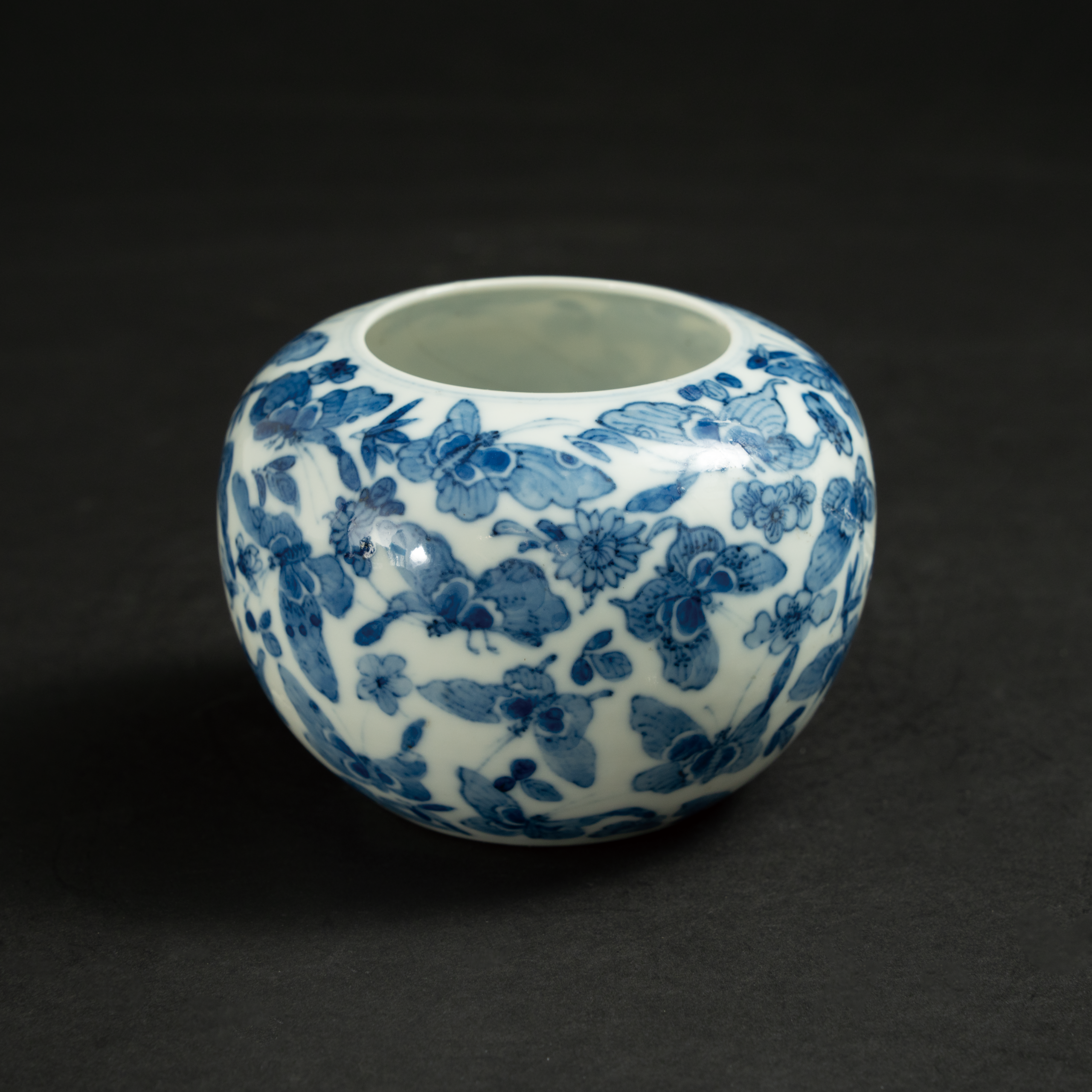 Lot 100 A BLUE AND WHITE 'BUTTERFLIES AND FLOWERS' WATER POT
19TH CENTURY
清19世纪 青花百蝶纹小缸
